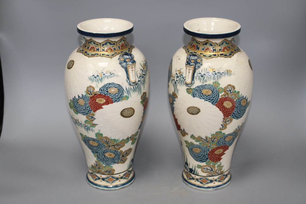 A pair of Satsuma vases, decorated with chrysanthemums, irises and storks, with beast head lug handles, height 31cm